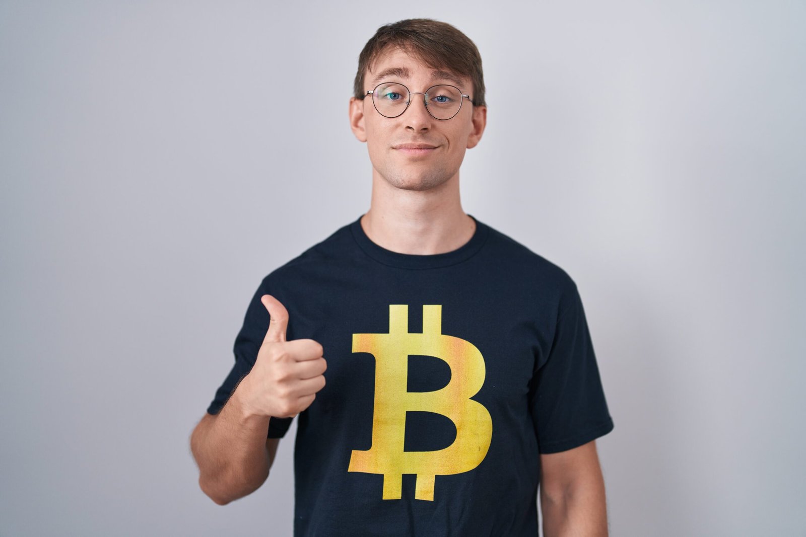 Guy in a Bitcoin t-shirt smiling and giving a thumbs up