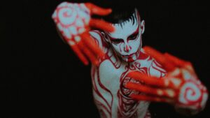 Artistic image of a man covered in red paint, representing the sexy-spooky vibe of Colombian folklore monsters for CamboysHub’s Halloween flirting guide.