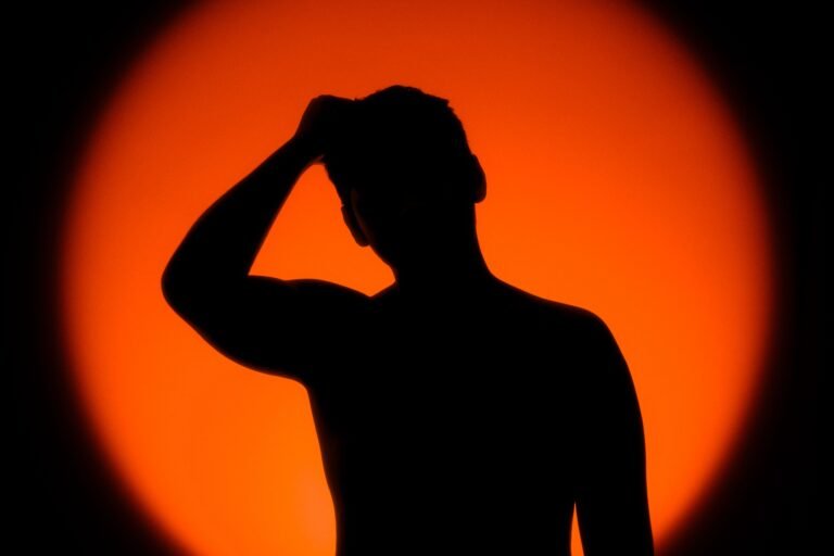 Silhuett av en person foran en oransje solnedgang