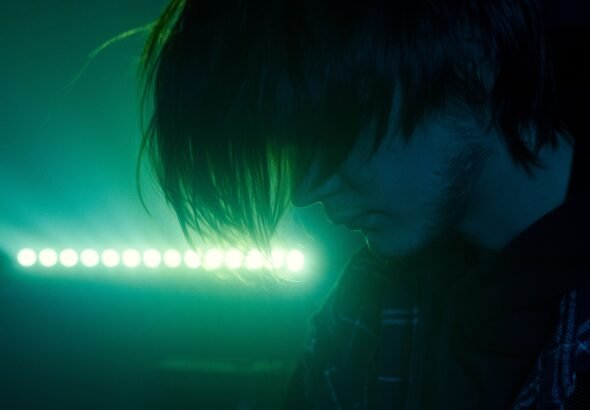 Man illuminated by green neon light
